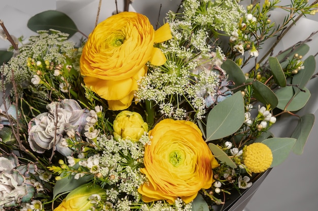 Bouquet giallo di fiori gialli e arancioni su sfondo grigio grigio