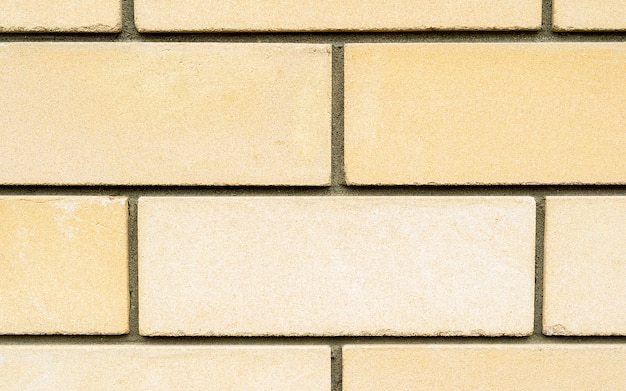 Yellow brick stone wall as a texture background, high resolution building wall macro image. The texture of the stone wall. Stone in the section. Background. Pebbles