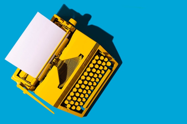 Yellow bright typewriter on blue surface