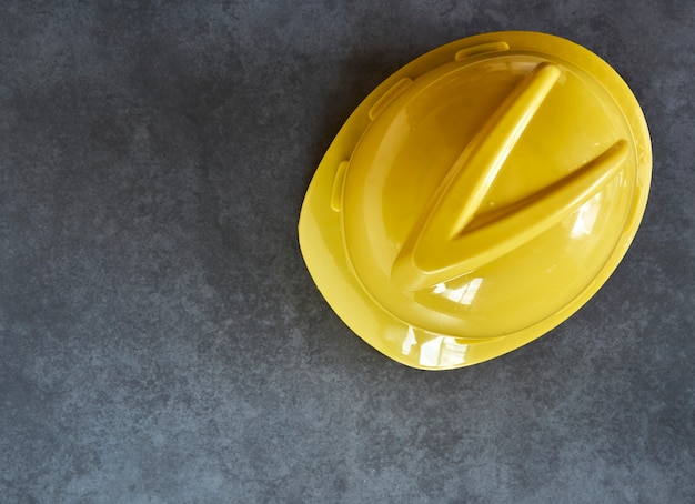 Casco di costruzione giallo sul bordo di legno