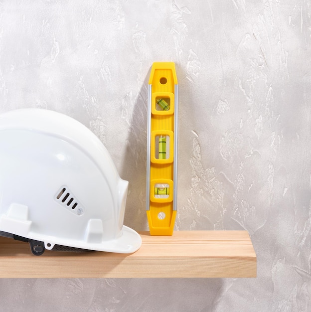 Yellow building level and white protective helmet for the head Copy space for text