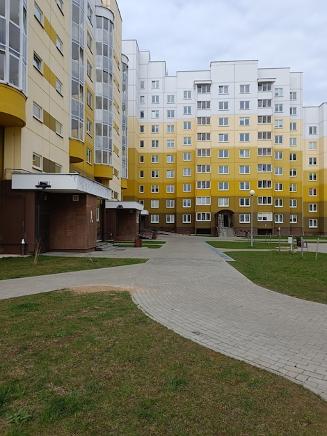 A yellow building with a green lawn and a yellow building with the word apartment on it