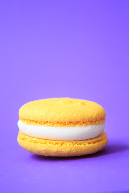 Yellow Cake macaron or macaroon on purple wall. colorful almond cookies. French macaroon cake 