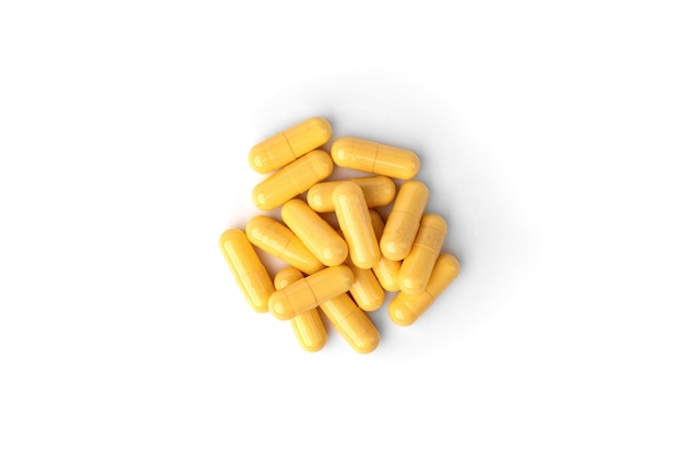 Yellow capsules or pills isolated on white background.