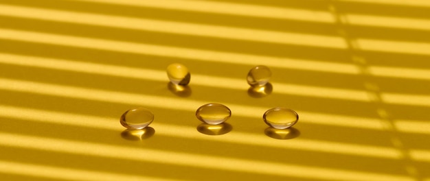 Yellow capsules with fish oil on a yellow background close up