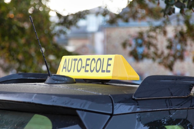 Yellow car roof sign with written in it in French AutoEcole meaning in English Driving school