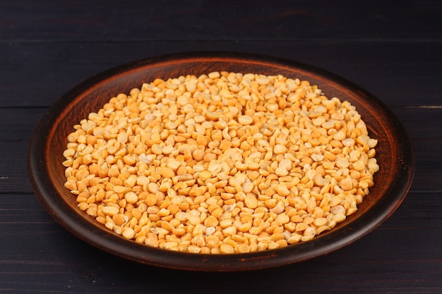 Yellow chopped peas in a plate on a dark surface