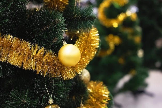 Yellow christmas ball on spruce close up