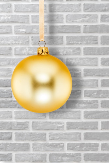 Yellow Christmas ball and a wall on the background