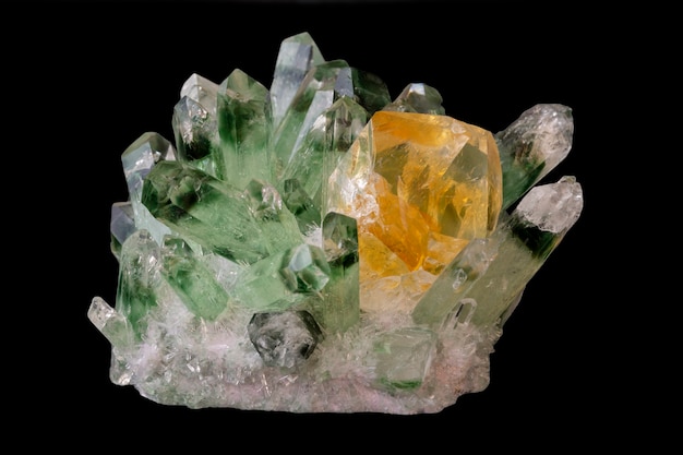 Cristallo citrino giallo tra cristalli di quarzo verde isolati su fondo nero. minerali geologici