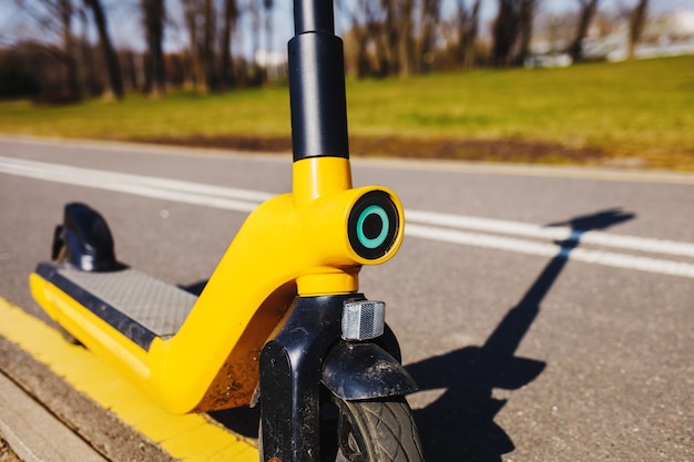 Yellow city electronic scooter in the park. eco-friendly vehicle