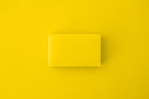 Yellow cleaning sponge on a yellow background. The view from the top. Space for text