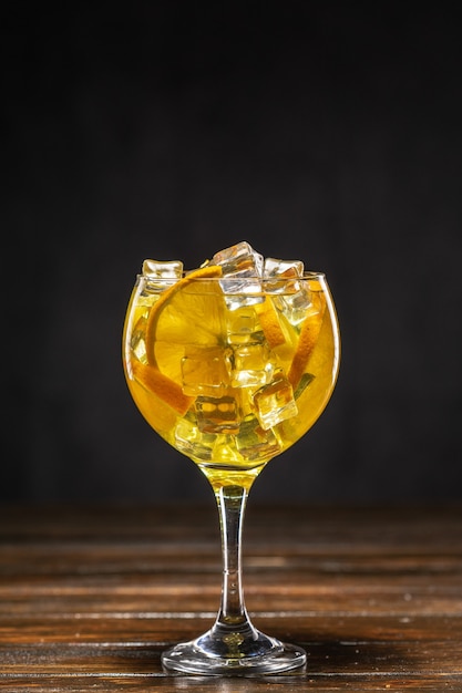 Yellow cocktail with ice and orange slices