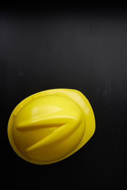 Yellow color hardhat against blackboard