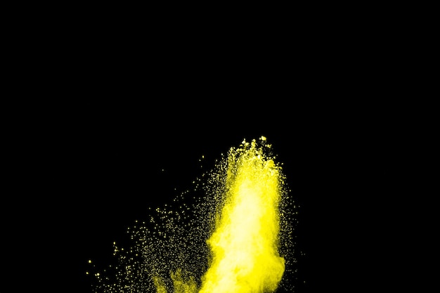 Esplosione di polvere di colore giallo su sfondo nero.