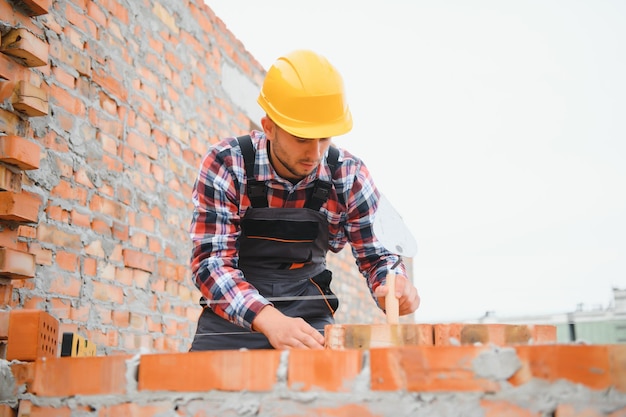 Yellow colored hard hat young man working in uniform at construction at daytime