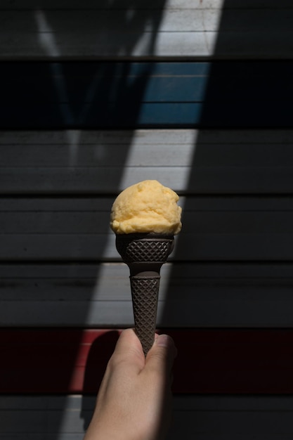 Foto cono di gelato di colore giallo con sottili luci del sole