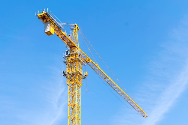 Yellow construction crane on blue sky