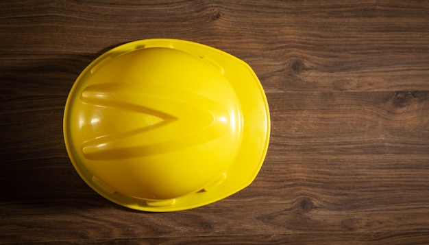 Yellow construction helmet on the wooden table