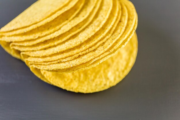 Yellow corn taco shells on a gray background.