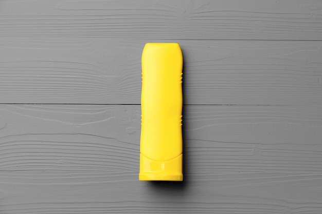 Photo yellow cosmetic container on gray background top view flat lay