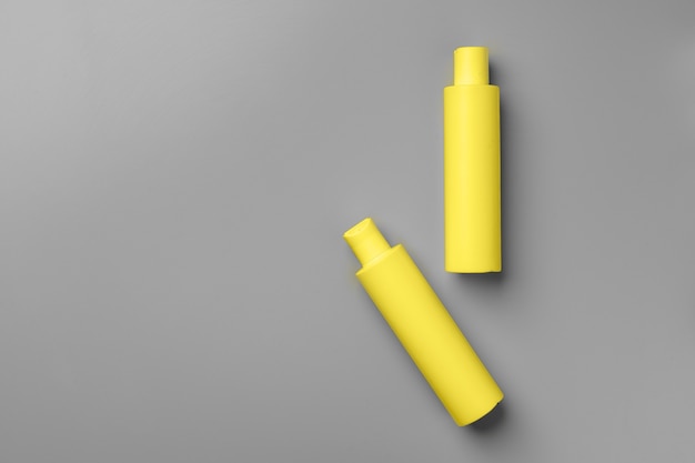 Yellow cosmetic container on gray background