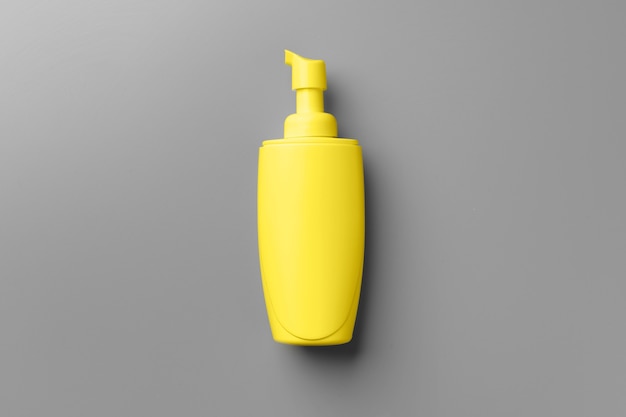Yellow cosmetic container on gray top view