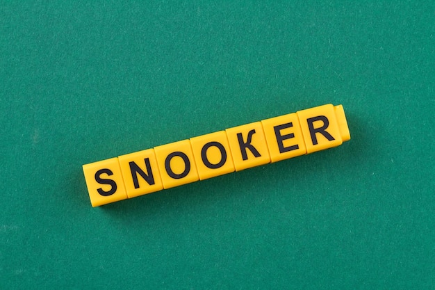 Yellow cubes with inscription snooker on green background space for text flat lay