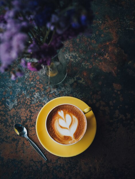 yellow cup of coffee latte art in coffee shop cafe