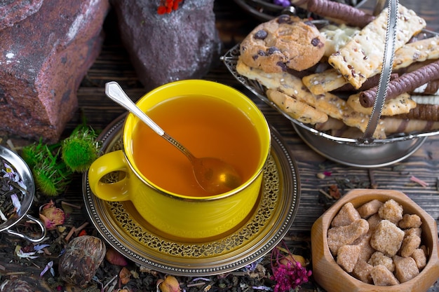 A yellow cup of tea with a spoon in it