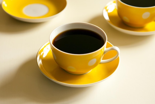 Yellow cups with black tea. retro tea-set. vintage ceramic mug and plate