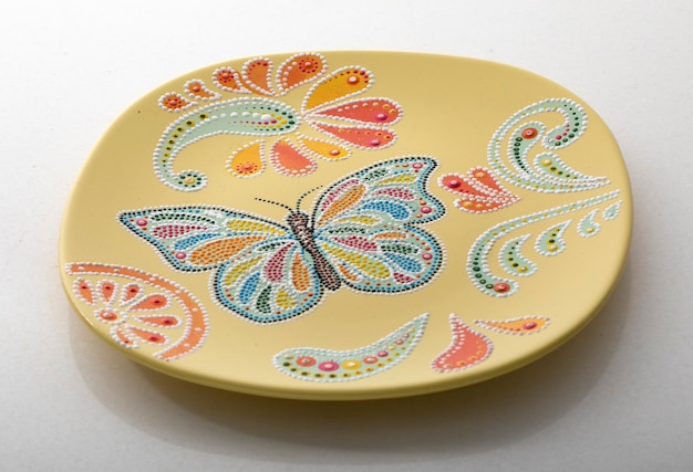 Yellow decorative plate for interior decoration on a white background