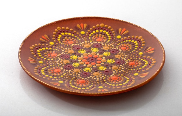 Yellow decorative plate with a mandala pattern On a white background