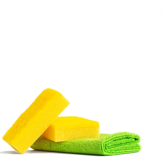 Желтые губки и зеленое полотенце из микрофибры.