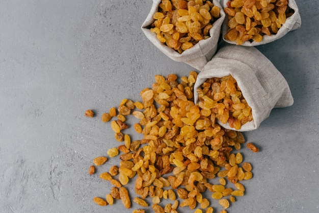 Yellow dry raisins spilled from textile sack 