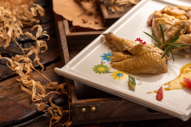 The yellow duck in the long white plate is on the wooden table