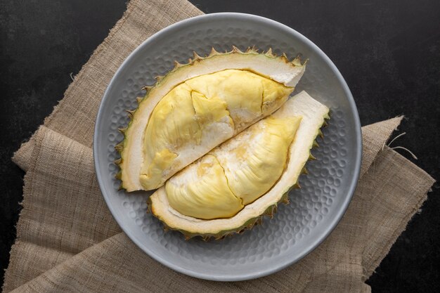 Yellow durian monthong flesh in metal plate on dark texture background, king of fruits