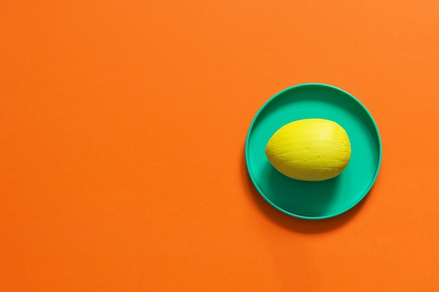 Photo yellow easter egg on a bright orange background copy space