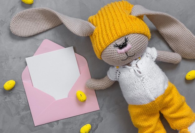 Yellow Easter eggs bunny toy and envelope with copy space
