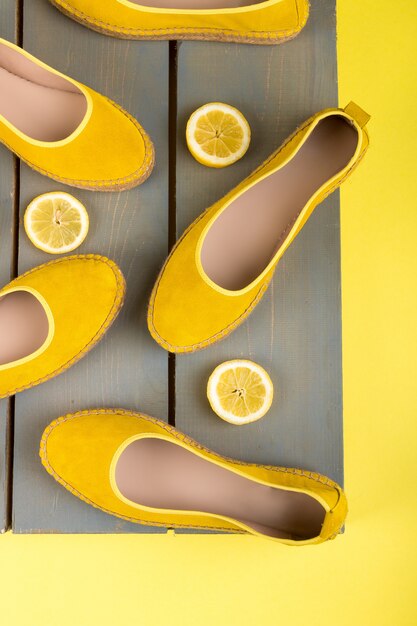 Yellow espadrilles shoes near slices of lemon