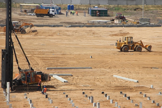 Yellow excavator on construction site working on pile of gravel Construction