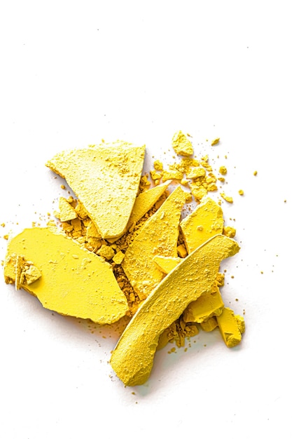 Foto polvere di ombretto giallo come primo piano tavolozza trucco isolato su sfondo bianco cosmetici schiacciati e texture di bellezza