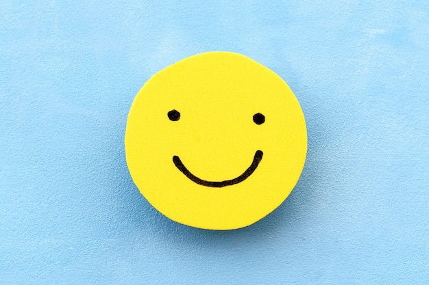 Photo yellow face on a blue background the concept of positive mood emotions and feedback