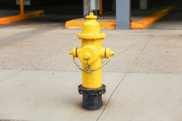 A yellow fire hydrant with a chain on it