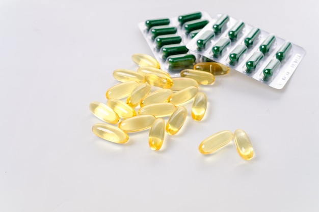 Yellow fish oil capsules, omega 3, on white background