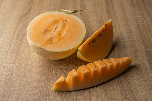 Photo yellow flesh melon cut into halves it is a fruit that contains vitamin c, vitamin a, beta-carotene, calcium, phosphorus and iron.