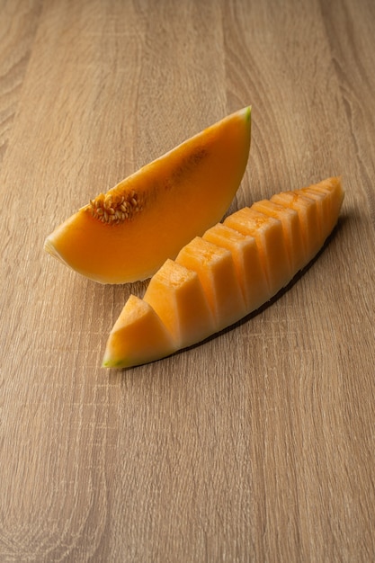 Photo yellow flesh melon cut into halves it is a fruit that contains vitamin c, vitamin a, beta-carotene, calcium, phosphorus and iron.