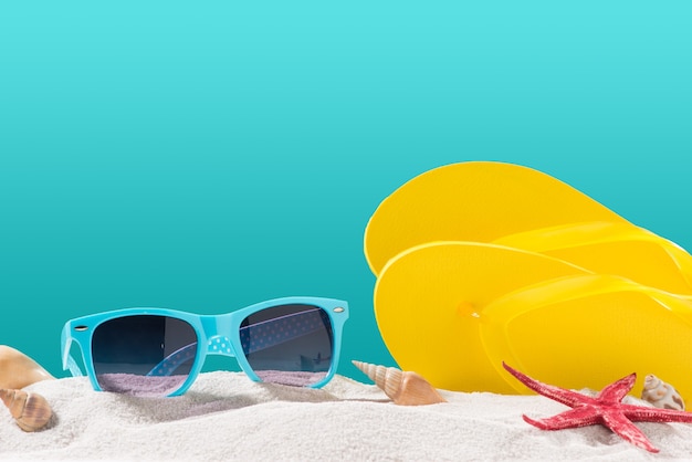 Yellow flip flops on beach against blue background.