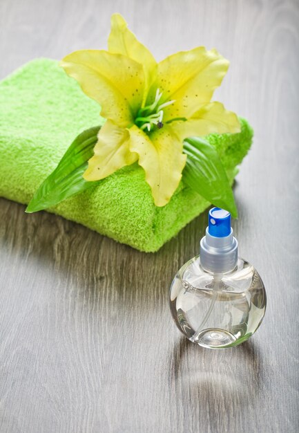 Yellow flower on towel and transparent bottle