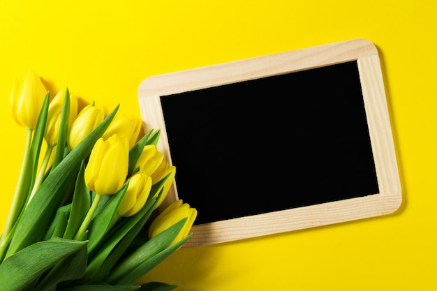 Photo yellow flowers and a blackboard